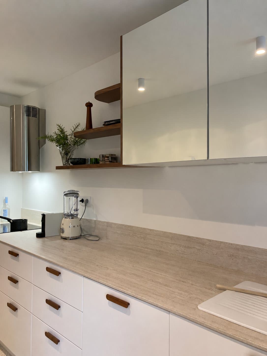 Façades hautes en miroir et étagères en noyer
